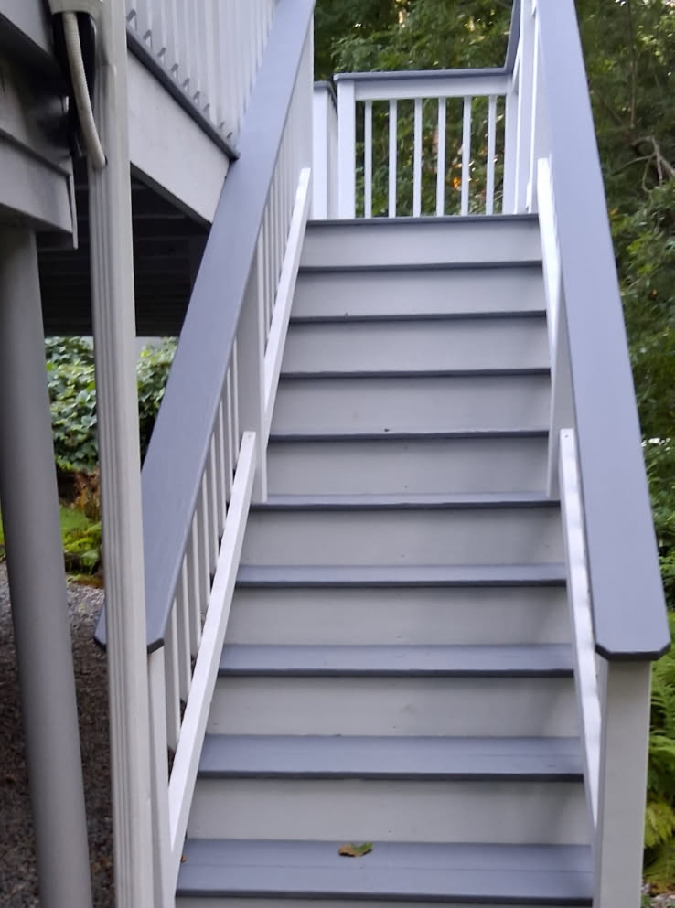 The same deck stairs repainted with grey treads, charcoal caps and crisp white balusters