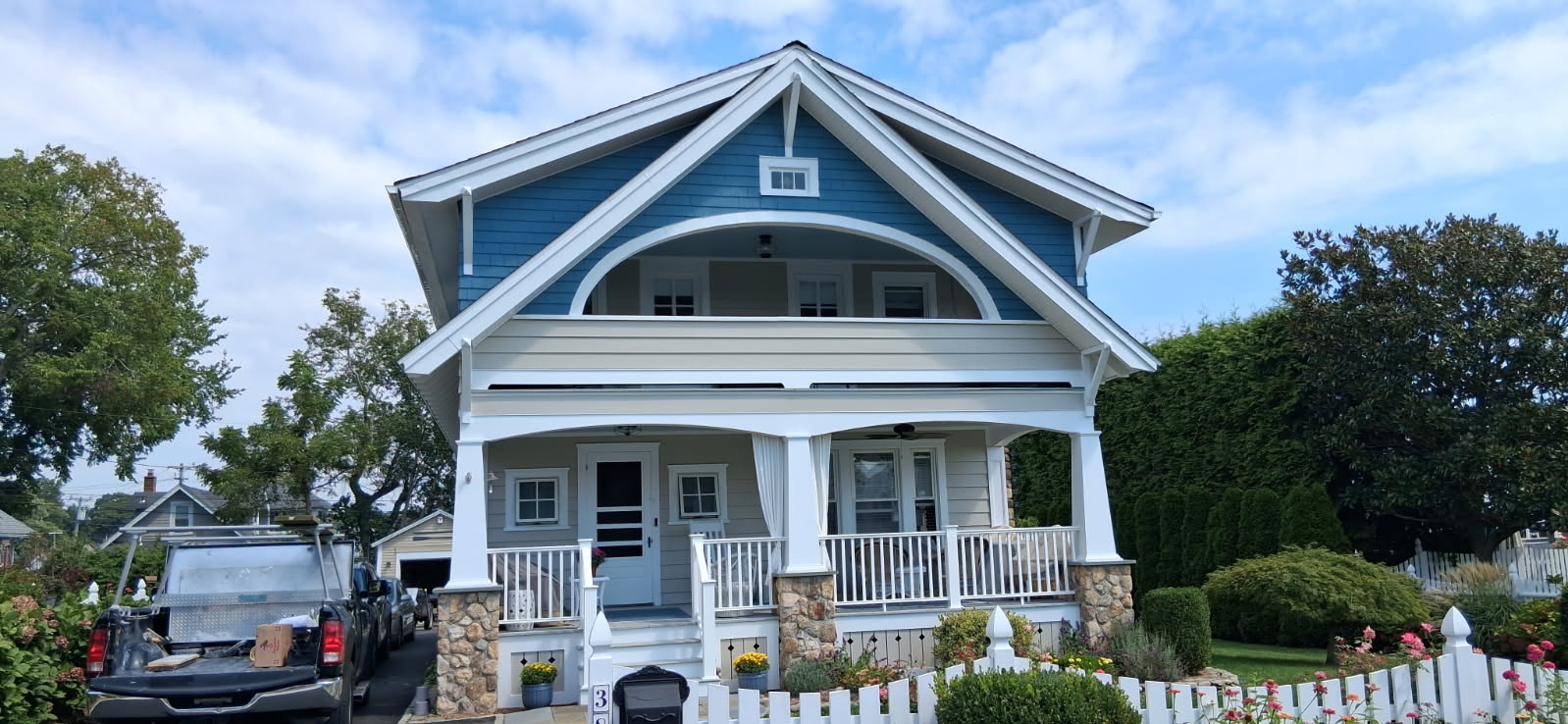 The same coastal bungalow after repainting in rich blue with crisp white trim